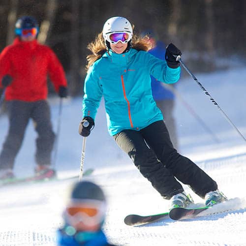 Woman in blue jacket skiing at Loon
